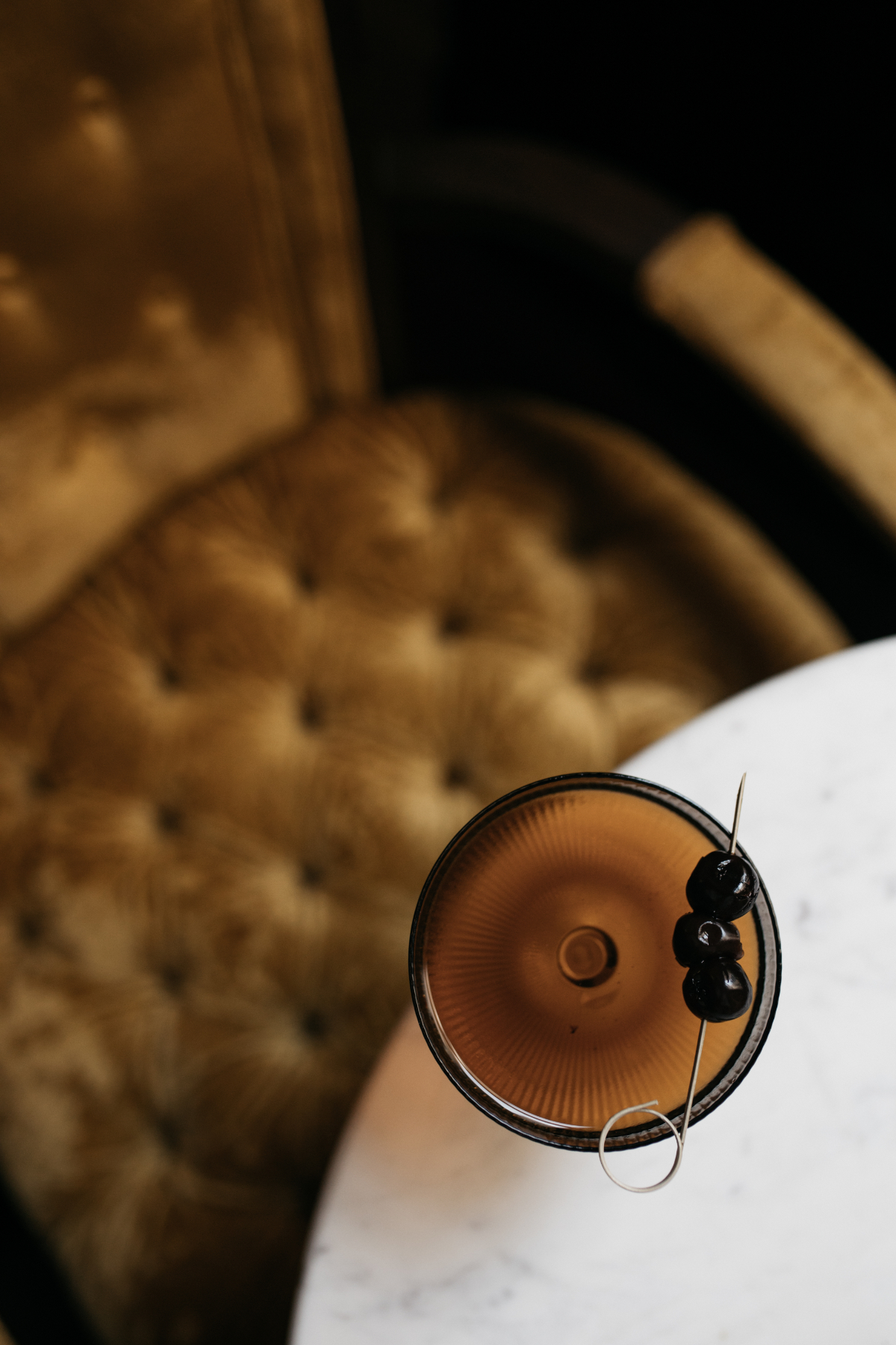 a cocktail on a table with a chair in the background