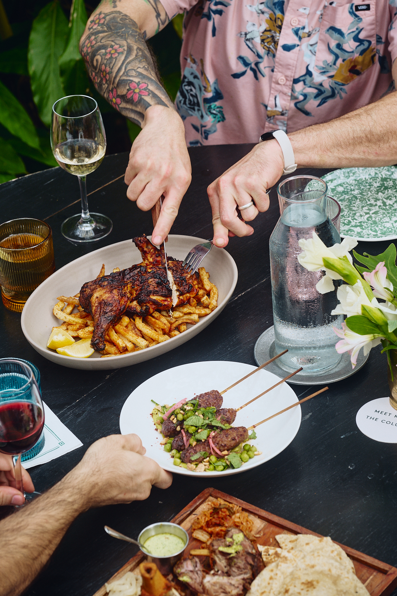 A table with food and drinks, and people eating.